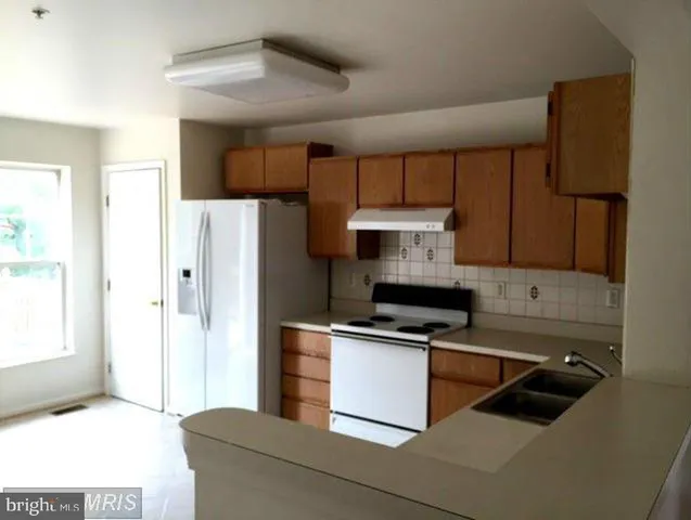 a kitchen with stainless steel appliances a refrigerator and a stove