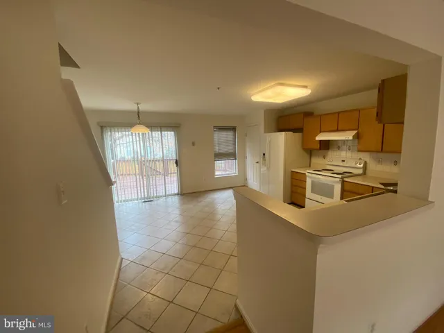 a kitchen with granite countertop a refrigerator and a stove top oven