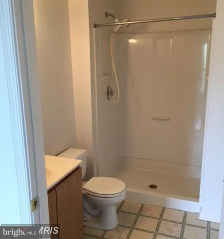a bathroom with a shower a toilet and a sink