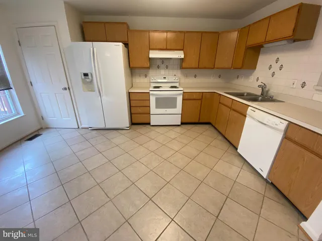 a kitchen with a sink a stove and a refrigerator