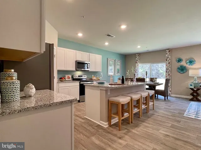 a large kitchen with kitchen island granite countertop a large counter top and stainless steel appliances