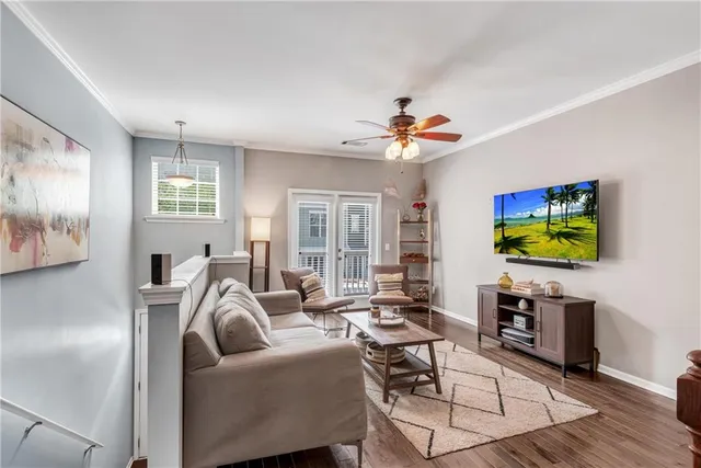 a living room with furniture a flat screen tv and kitchen view