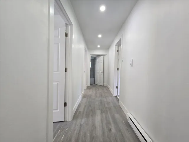 a view of a hallway with wooden floor