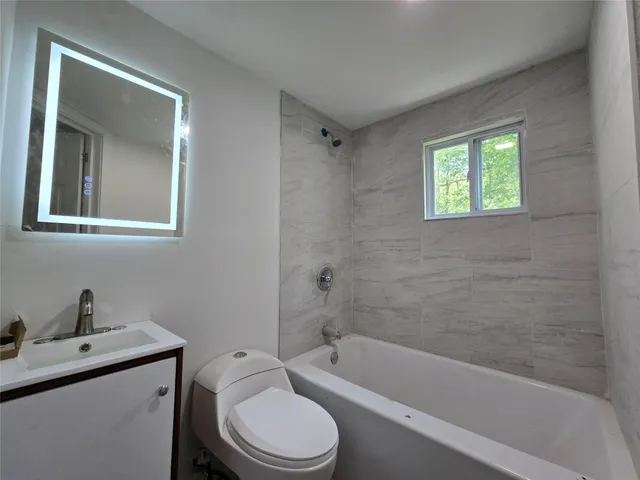 a bathroom with a granite countertop toilet a sink and bathtub