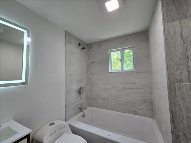 a bath room with a toilet and a bath tub
