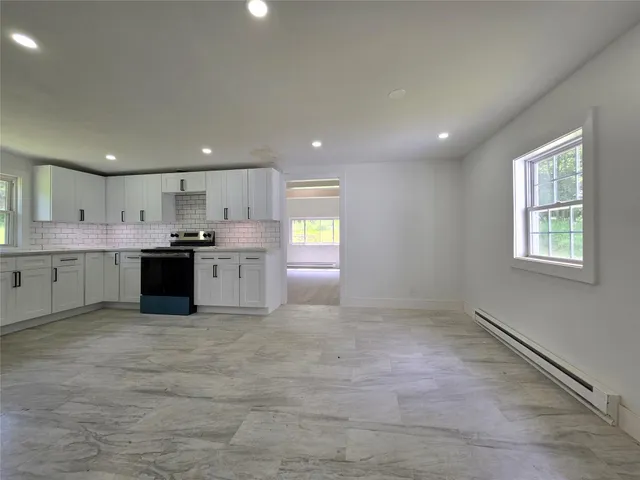 a large kitchen with a stove a refrigerator a sink a microwave and cabinets