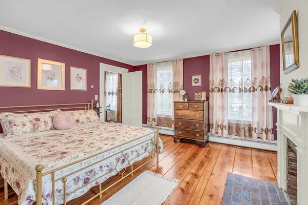 a living room with hard wood flooring and a bed