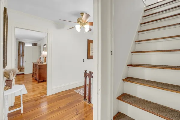 a view of a livingroom with wooden floor and stairs