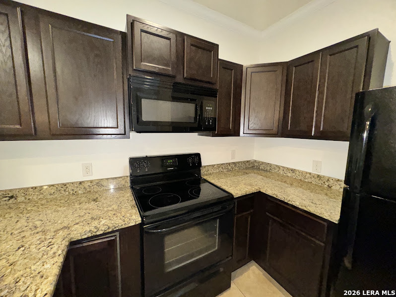 16808 Dancing Ava, Unit 2 Selma, TX 78154 - Photo 5 of 15 a kitchen with granite countertop stainless steel appliances and wooden cabinets