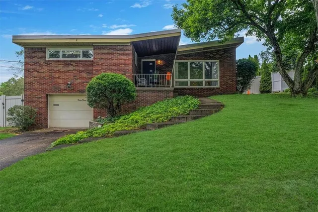 a front view of a house with a garden and plants