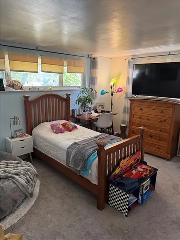 a bedroom with bed table and window
