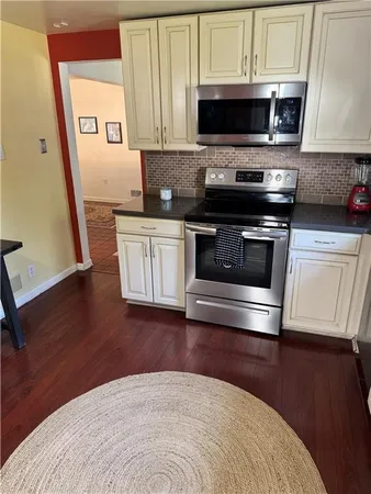 a kitchen with stainless steel appliances a stove a microwave a sink and cabinets