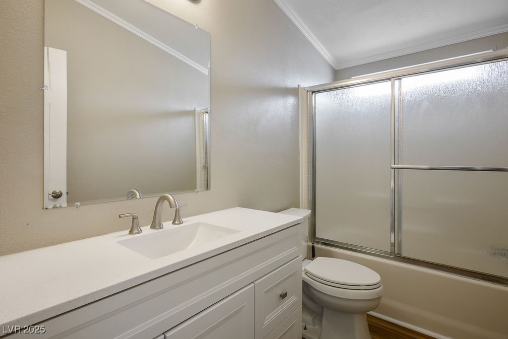 1100 East Gamebird Road Pahrump, NV 89048 - Photo 32 of 37 Full bath featuring crown molding, toilet, vanity, and bath / shower combo with glass door
