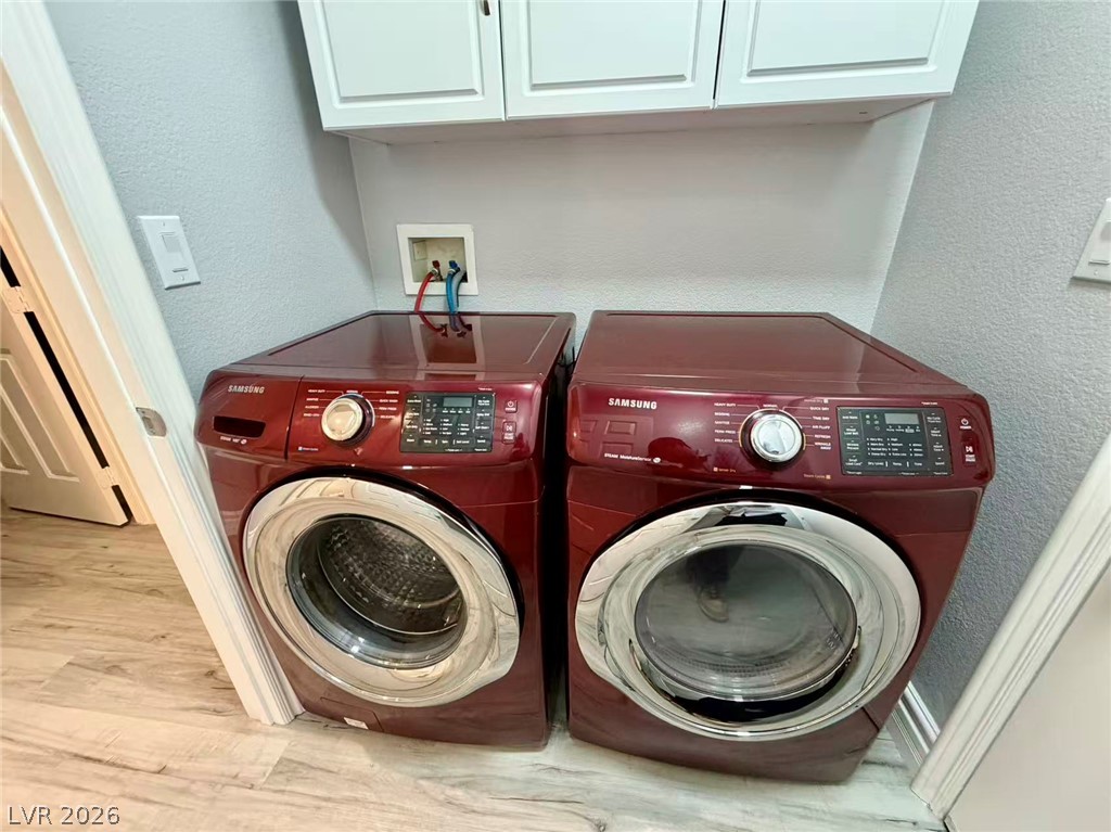 135 Tall Ruff Drive Las Vegas, NV 89148 - Photo 11 of 29 Streamlined laundry area with a matching washer and dryer beneath practical storage cabinetry.