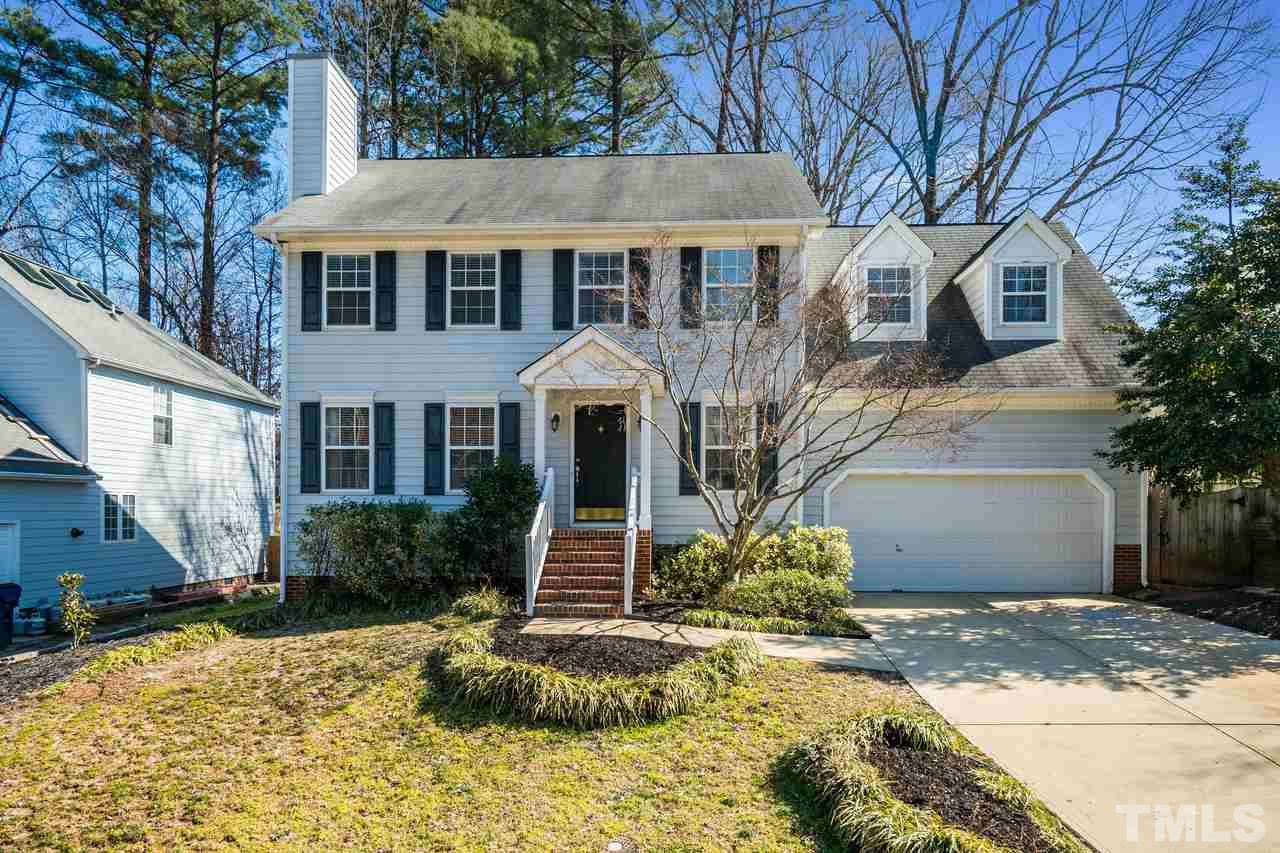 8727 Harps Mill Road Raleigh, NC 27615 - Photo 1 of 25 a front view of a house with a yard and garage