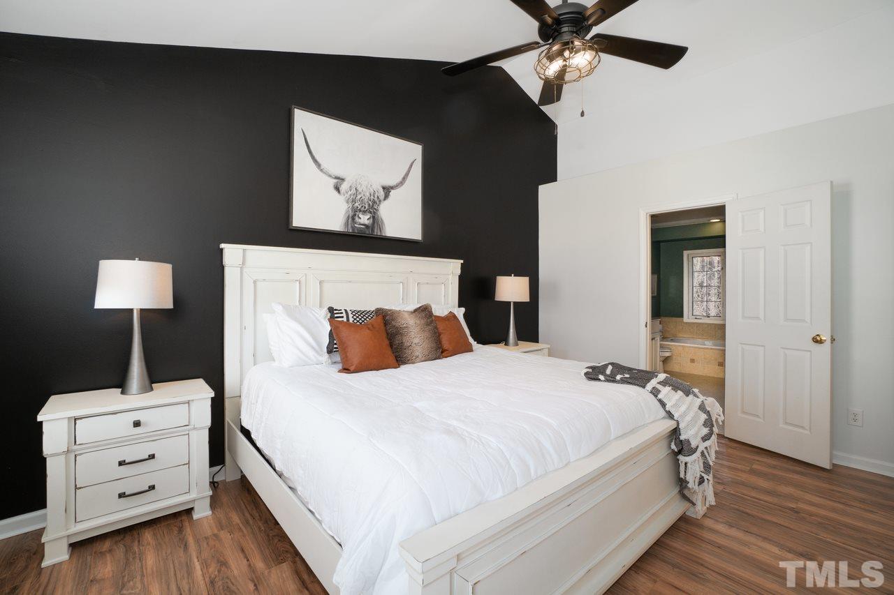 8727 Harps Mill Road Raleigh, NC 27615 - Photo 13 of 25 a bedroom with a bed and a lamp on the dresser