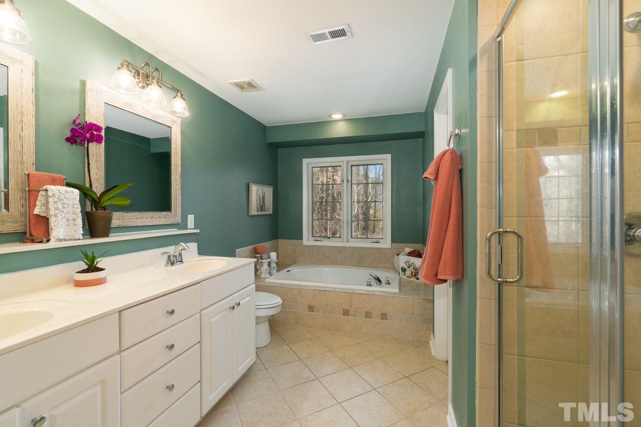 8727 Harps Mill Road Raleigh, NC 27615 - Photo 16 of 25 a spacious bathroom with a tub sink and mirror