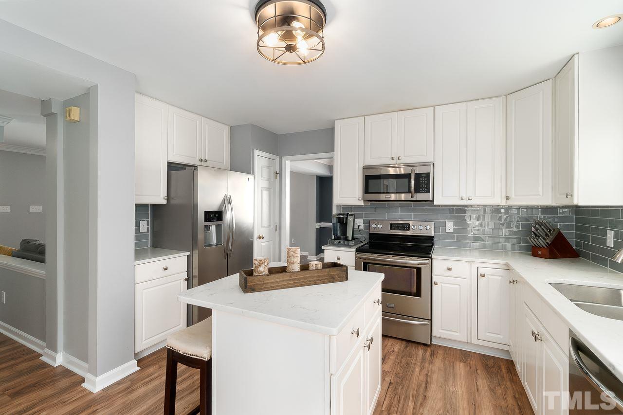 8727 Harps Mill Road Raleigh, NC 27615 - Photo 9 of 25 a kitchen with a refrigerator stove and microwave