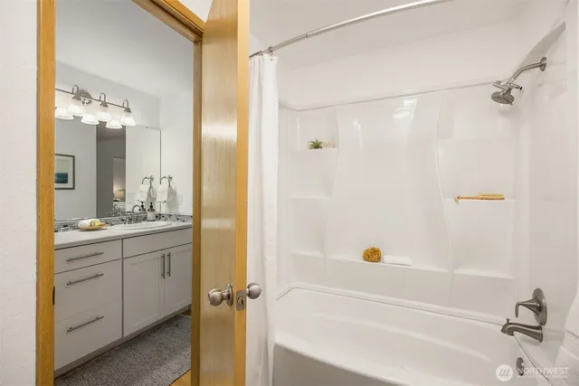 a bathroom with a granite countertop shower a sink and a mirror
