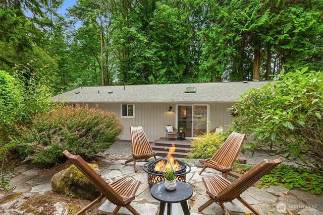 a view of a patio with table and chairs and potted plants with large tree