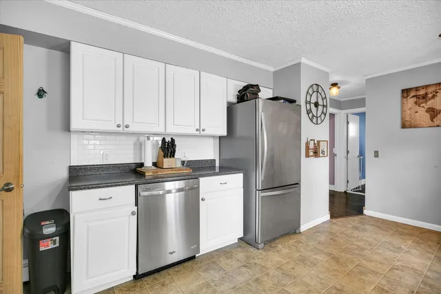 a kitchen with stainless steel appliances granite countertop a refrigerator a stove and a sink