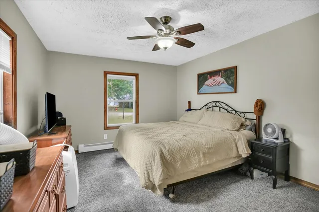 a bedroom with a bed a window and a flat screen television