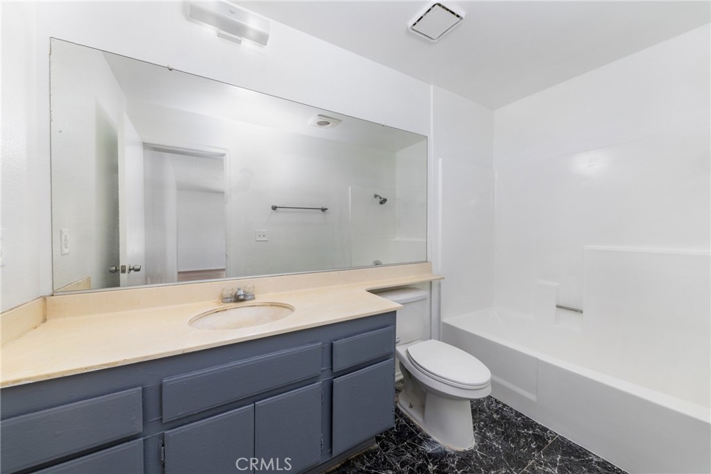 1800 East Old Ranch Road, Unit 134 Colton, CA 92324 - Photo 19 of 22 a bathroom with a sink toilet a mirror and shower
