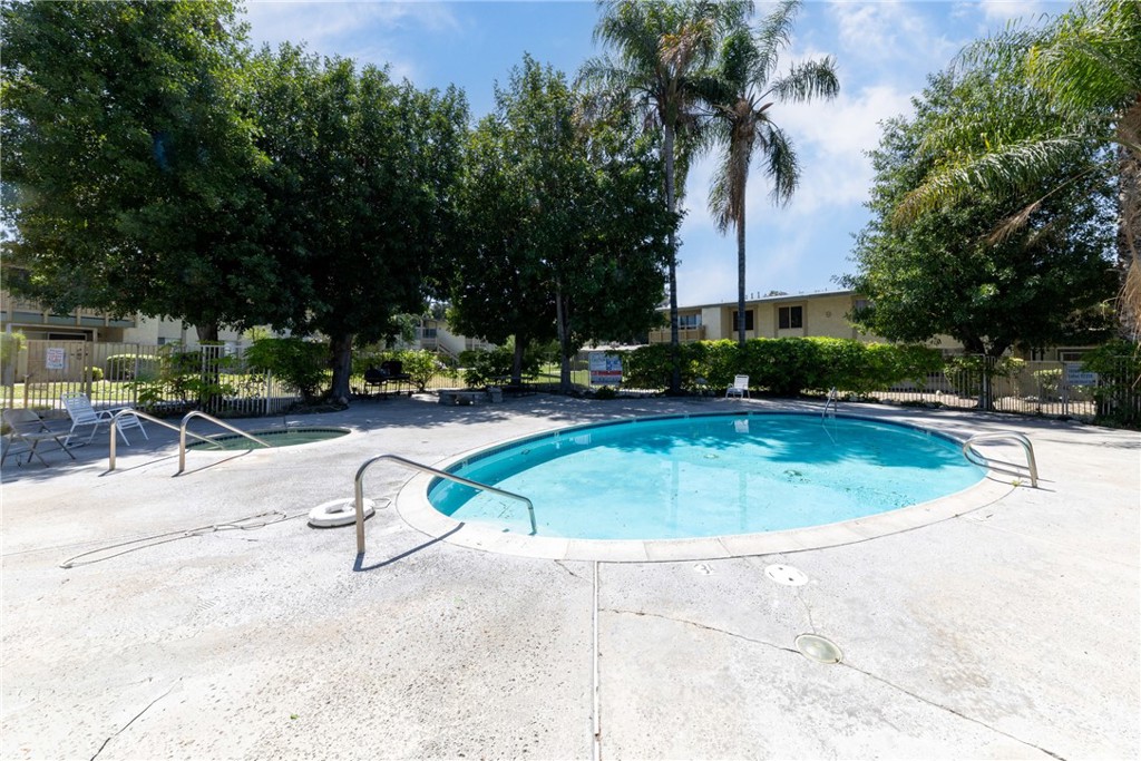 1800 East Old Ranch Road, Unit 134 Colton, CA 92324 - Photo 22 of 22 a view of a swimming pool with a bench and trees in the background