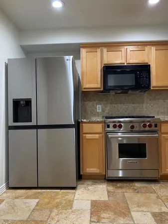 a kitchen with granite countertop a refrigerator and a stove