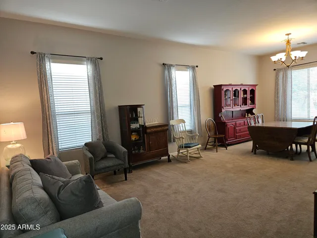 a living room with furniture a chandelier and a window
