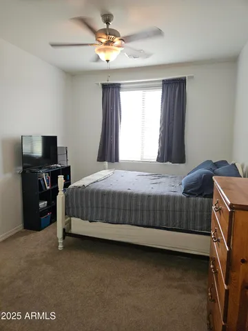 a bedroom with a bed and a ceiling fan