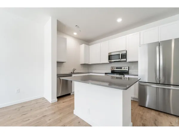 a kitchen with a refrigerator a microwave a sink and a stove