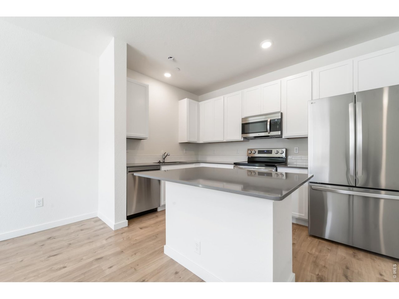 3913 Net Street Evans, CO 80620 - Photo 3 of 19 a kitchen with a refrigerator a microwave a sink and a stove