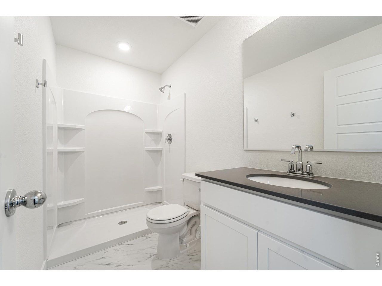 3913 Net Street Evans, CO 80620 - Photo 10 of 19 a bathroom with a granite countertop sink a toilet a mirror and shower