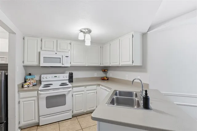 a kitchen with white cabinets and white appliances