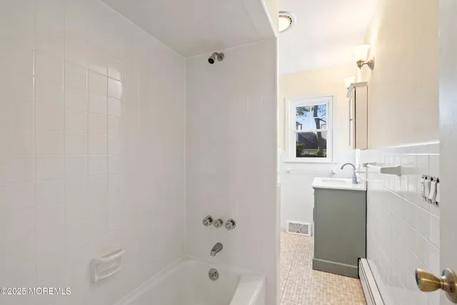 a bathroom with a bathtub sink vanity and mirror