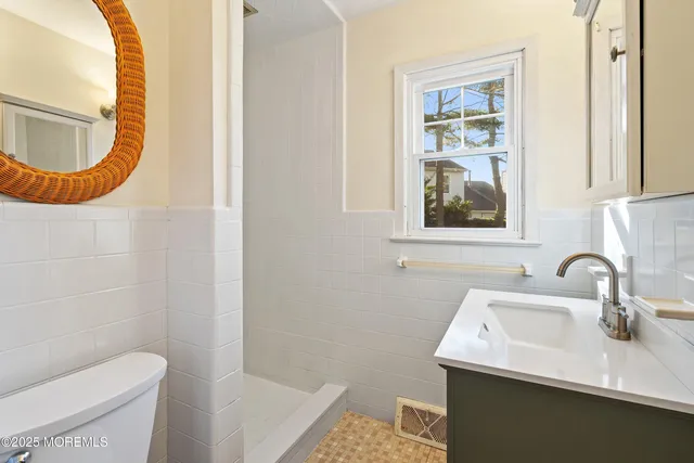 a bathroom with a sink a toilet and a mirror