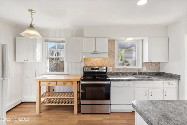 a kitchen with granite countertop a stove and a wooden floors