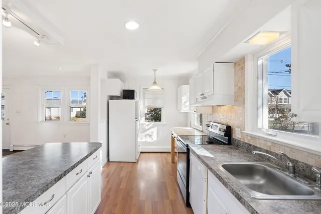 a kitchen with a sink a stove and cabinets