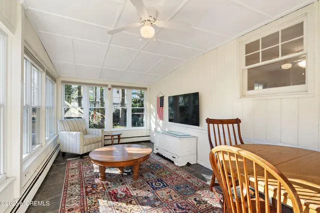a living room with furniture a flat screen tv and windows