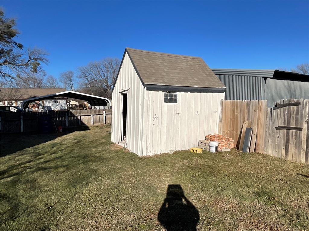 207 College Street Chico, TX 76431 - Photo 7 of 20 View of shed featuring a fenced backyard and a carport