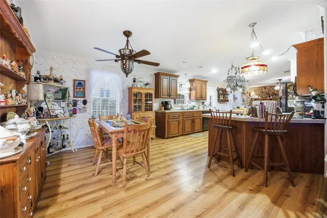 a kitchen with stainless steel appliances granite countertop a refrigerator a stove top oven a sink dishwasher and wooden cabinets with wooden floor