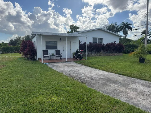 a view of a house with a yard and sitting area