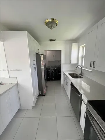 a kitchen with a sink a refrigerator and a stove