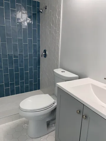 a white toilet sitting next to a bathroom sink
