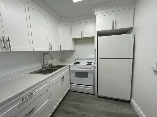 a kitchen with a refrigerator sink and cabinets