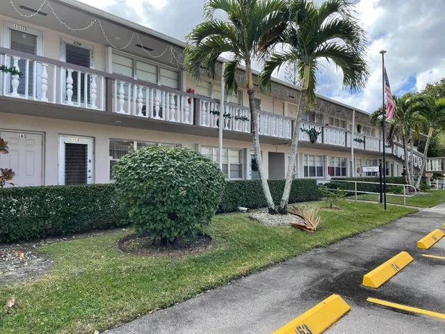a view of a building with a yard and potted plants