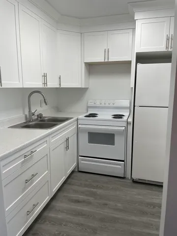 a kitchen with white cabinets and white appliances