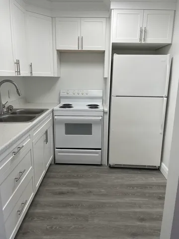a kitchen with white cabinets and white appliances