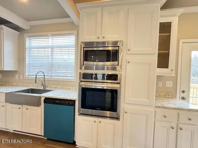 a kitchen with granite countertop white cabinets and white appliances